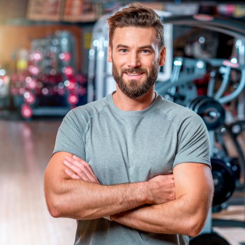 a man with a beard standing in a gym