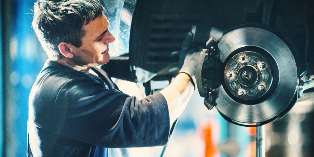 a man is working on a car's brake