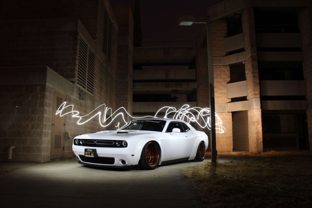 a white car with lights on it in front of a building