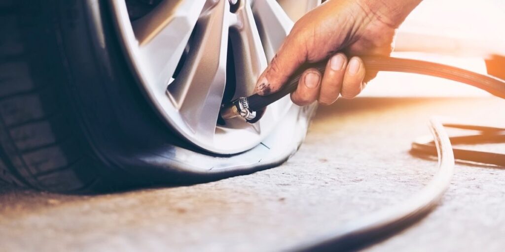 a person is using a hose to change the tire on a car