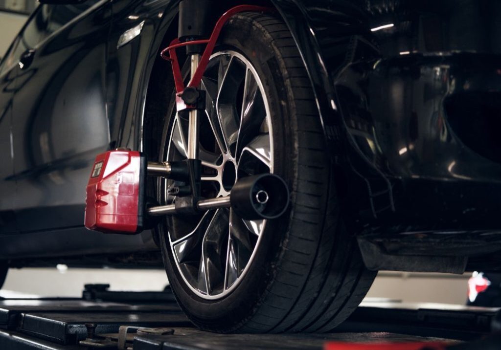 a car is being lifted on a lift with a tire on it