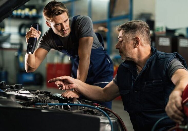two men working on a car in a garage