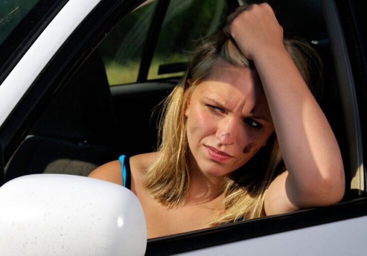 a woman is sitting in the driver's seat of a car and the car won't start